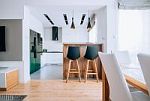 Jasny salon zaaranżowany w stylu skandynawskim z drewnianą podłogą i designerskimi lampami
